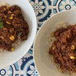 Photo of two dishes of chilli con carrot mince on served on rice