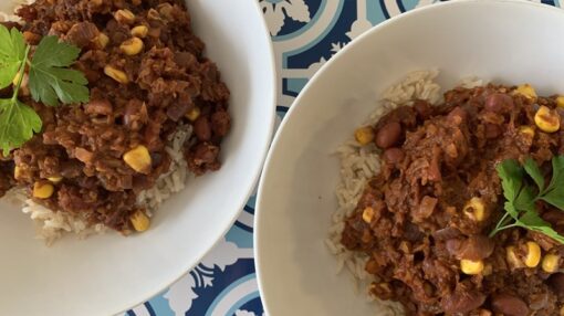 Photo of two dishes of chilli con carrot mince on served on rice