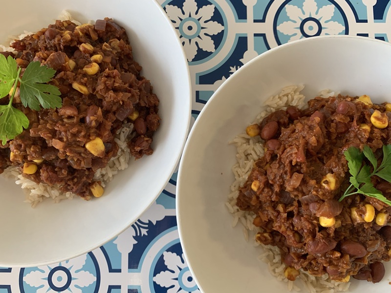 Photo of two dishes of chilli con carrot mince on served on rice